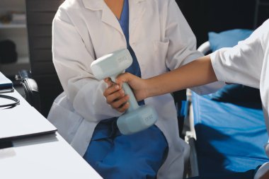 Tanımlanamayan fiziksel terapi sırasında mavi el ağırlığı kullanır