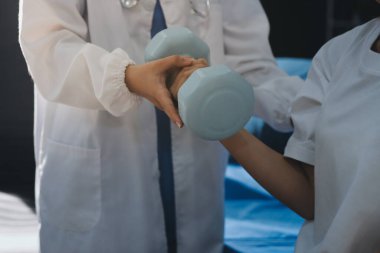 Tanımlanamayan fiziksel terapi sırasında mavi el ağırlığı kullanır