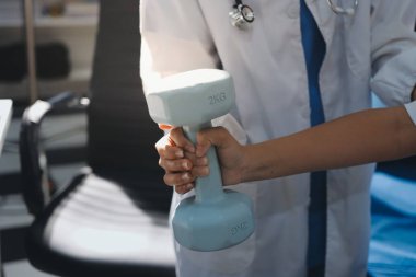 Tanımlanamayan fiziksel terapi sırasında mavi el ağırlığı kullanır