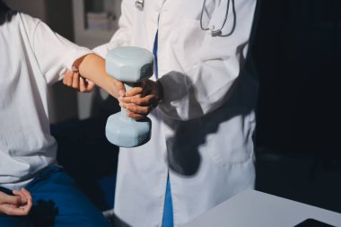 Tanımlanamayan fiziksel terapi sırasında mavi el ağırlığı kullanır