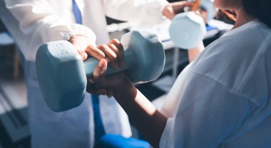 Tanımlanamayan fiziksel terapi sırasında mavi el ağırlığı kullanır