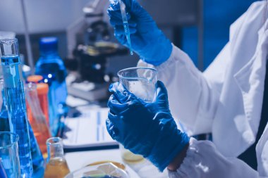 Bilimadamı laboratuarda tıbbi örnekleri mikro plakaya yerleştiriyor.