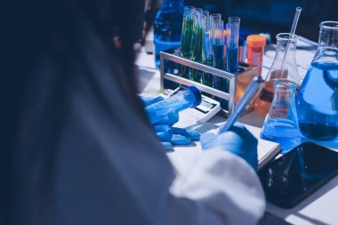 Bilimadamı laboratuarda tıbbi örnekleri mikro plakaya yerleştiriyor.