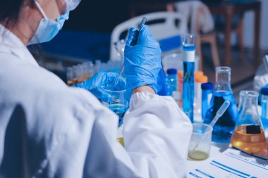 Bilimadamı laboratuarda tıbbi örnekleri mikro plakaya yerleştiriyor.