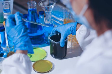 Bilimadamı laboratuarda tıbbi örnekleri mikro plakaya yerleştiriyor.