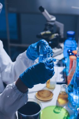 Bilimadamı laboratuarda tıbbi örnekleri mikro plakaya yerleştiriyor.