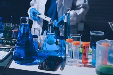 Bilimadamı laboratuarda tıbbi örnekleri mikro plakaya yerleştiriyor.