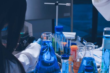 Bilimadamı laboratuarda tıbbi örnekleri mikro plakaya yerleştiriyor.