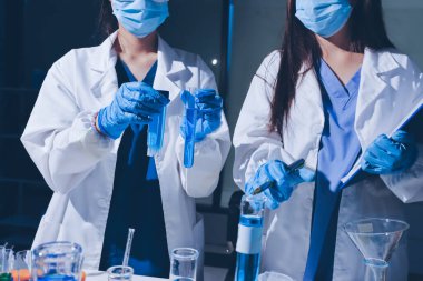 Bilimadamı laboratuarda tıbbi örnekleri mikro plakaya yerleştiriyor.