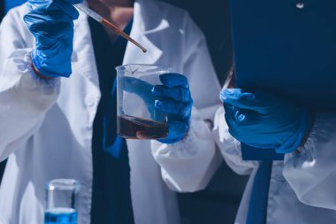 Bilimadamı laboratuarda tıbbi örnekleri mikro plakaya yerleştiriyor.