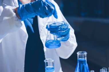 Bilimadamı laboratuarda tıbbi örnekleri mikro plakaya yerleştiriyor.