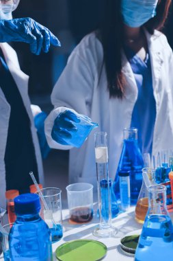 Bilimadamı laboratuarda tıbbi örnekleri mikro plakaya yerleştiriyor.