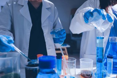 Bilimadamı laboratuarda tıbbi örnekleri mikro plakaya yerleştiriyor.