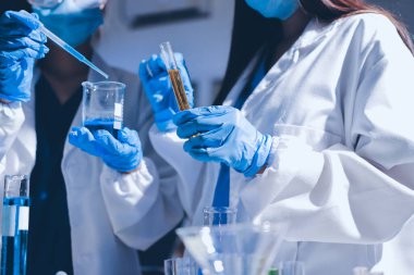 Bilimadamı laboratuarda tıbbi örnekleri mikro plakaya yerleştiriyor.