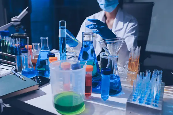 Bilimadamı laboratuarda tıbbi örnekleri mikro plakaya yerleştiriyor.