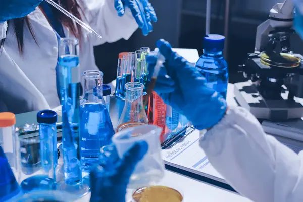 Bilimadamı laboratuarda tıbbi örnekleri mikro plakaya yerleştiriyor.