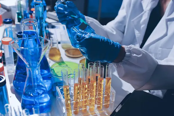 Bilimadamı laboratuarda tıbbi örnekleri mikro plakaya yerleştiriyor.