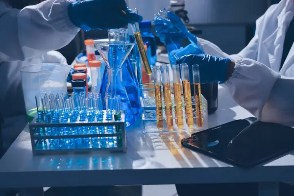 Bilimadamı laboratuarda tıbbi örnekleri mikro plakaya yerleştiriyor.