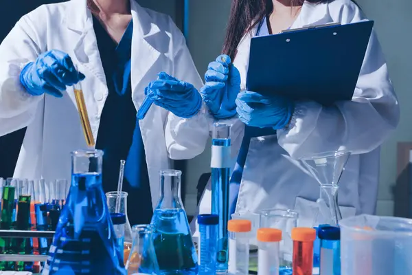 Bilimadamı laboratuarda tıbbi örnekleri mikro plakaya yerleştiriyor.