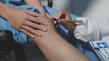 Doktor, hastanın dizini kontrol ediyor.