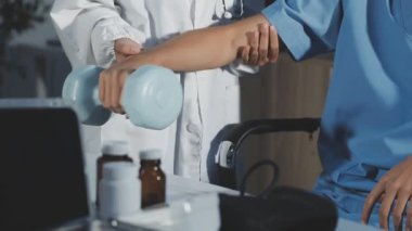 Erkek doktor elinde dambıl tutuyor..