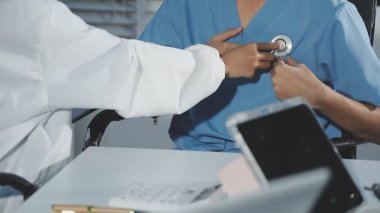 Kapat. Hastanedeki hastasını muayene eden doktor.