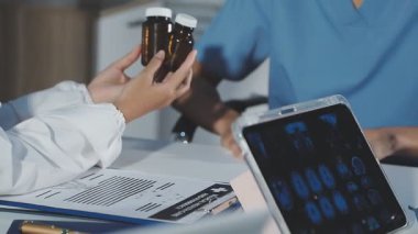 Doktor meslektaşlarına tıbbi tablet gösteriyor.