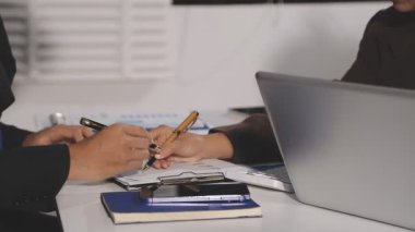 Genç adam ofiste çalışıyor, defterde oturuyor ve yazıyor, iş konsepti.