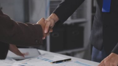 Kapat - arka plandaki ofis masasının üzerinden iş adamlarının el sıkışması