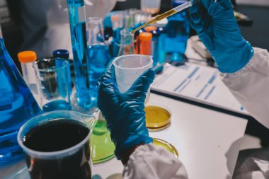 Bilimadamı laboratuarda tıbbi örnekleri mikro plakaya yerleştiriyor.