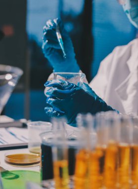 Bilimadamı laboratuarda tıbbi örnekleri mikro plakaya yerleştiriyor.