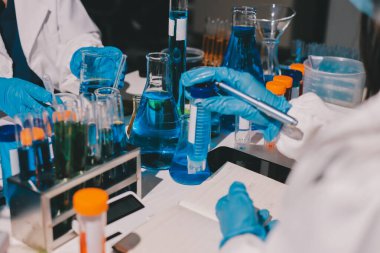 Bilimadamı laboratuarda tıbbi örnekleri mikro plakaya yerleştiriyor.