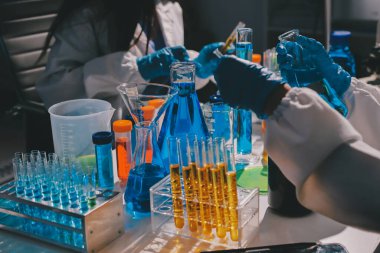 Bilimadamı laboratuarda tıbbi örnekleri mikro plakaya yerleştiriyor.