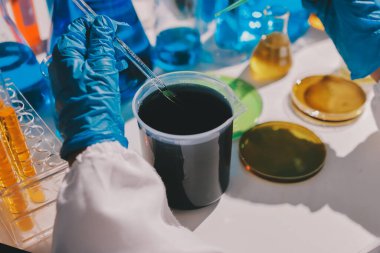 Bilimadamı laboratuarda tıbbi örnekleri mikro plakaya yerleştiriyor.