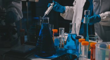 Bilimadamı laboratuarda tıbbi örnekleri mikro plakaya yerleştiriyor.