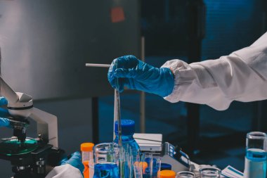 Bilimadamı laboratuarda tıbbi örnekleri mikro plakaya yerleştiriyor.