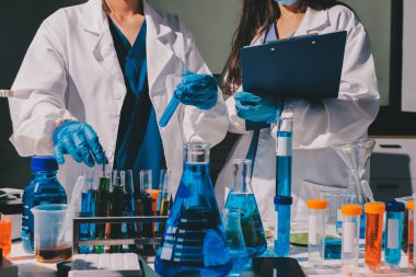 Bilimadamı laboratuarda tıbbi örnekleri mikro plakaya yerleştiriyor.