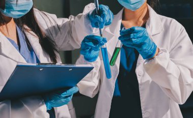 Bilimadamı laboratuarda tıbbi örnekleri mikro plakaya yerleştiriyor.