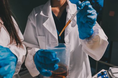 Bilimadamı laboratuarda tıbbi örnekleri mikro plakaya yerleştiriyor.