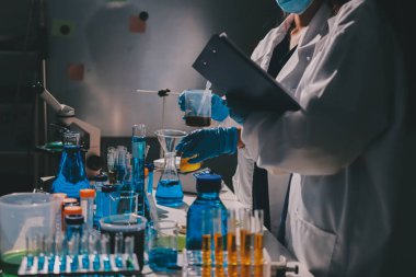 Bilimadamı laboratuarda tıbbi örnekleri mikro plakaya yerleştiriyor.