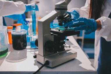 Bilimadamı laboratuarda tıbbi örnekleri mikro plakaya yerleştiriyor.