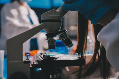 Bilimadamı laboratuarda tıbbi örnekleri mikro plakaya yerleştiriyor.