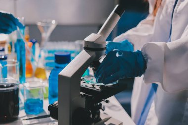 Bilimadamı laboratuarda tıbbi örnekleri mikro plakaya yerleştiriyor.