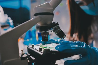 Bilimadamı laboratuarda tıbbi örnekleri mikro plakaya yerleştiriyor.