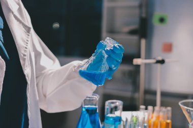 Bilimadamı laboratuarda tıbbi örnekleri mikro plakaya yerleştiriyor.