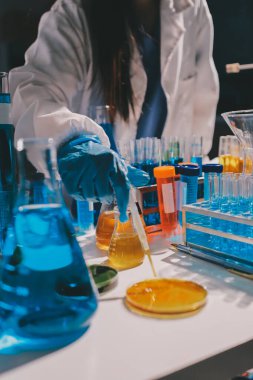 Bilimadamı laboratuarda tıbbi örnekleri mikro plakaya yerleştiriyor.