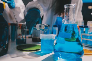 Bilimadamı laboratuarda tıbbi örnekleri mikro plakaya yerleştiriyor.