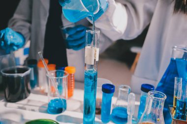 Bilimadamı laboratuarda tıbbi örnekleri mikro plakaya yerleştiriyor.