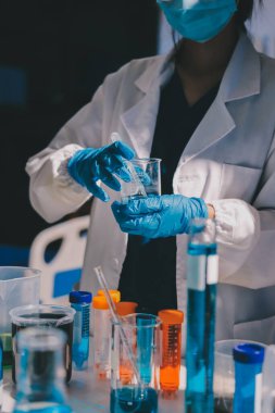 Bilimadamı laboratuarda tıbbi örnekleri mikro plakaya yerleştiriyor.