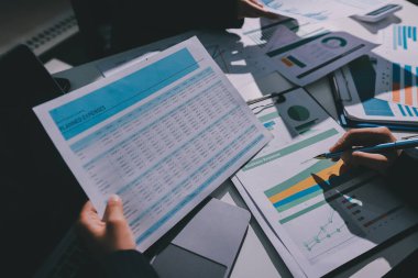 Finans veri harcamaları belgesi üzerinde çalışan bir grup iş kadını.